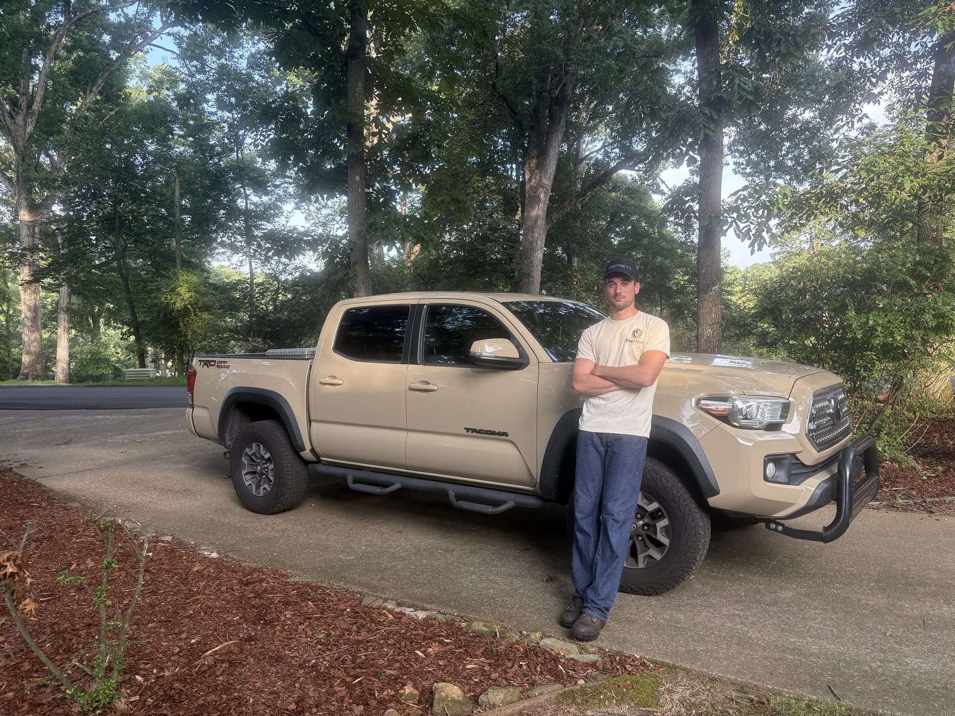The PreVent Exterior Care owner standing beside the company pickup under oaks in Florence
